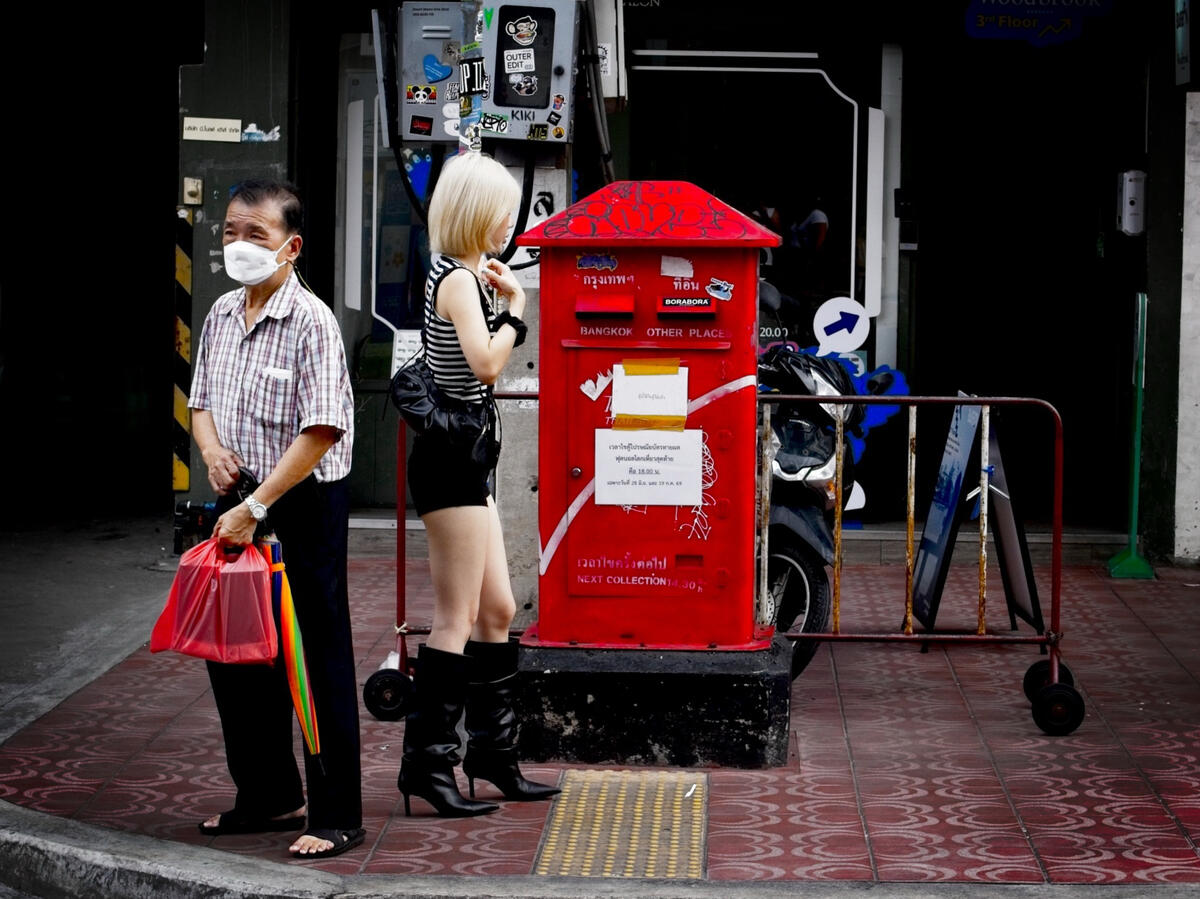 Bangkok, Thailand Street scene beside a red post box in Bangkok, Thailand.