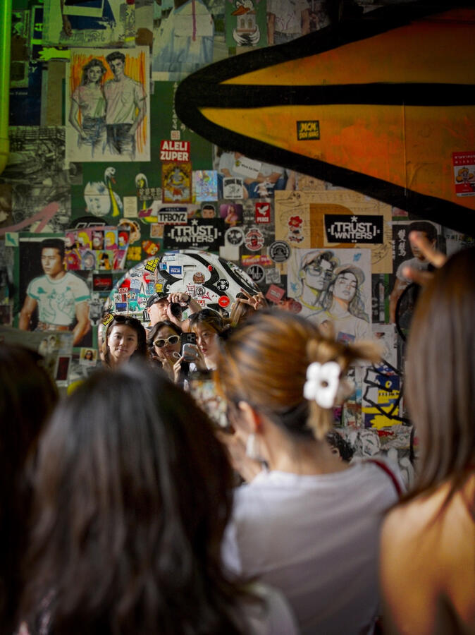 Bangkok, Thailand People reflected in a mirror surrounded by street art and stickers in Bangkok, Thailand.